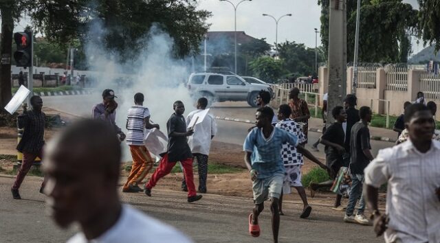 Protesters-run-for-safety-after-Nigerian-policemen-fire-teargas-at-demonstrators-during-the-Fearless-In-October-protest-over-bad-governance-in-Abuja-Nigeria__TopshotNigeriaPoliticsUnrest