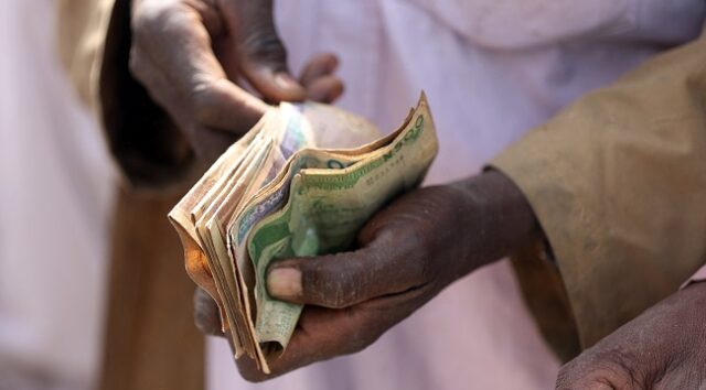 A-man-counts-bank-naira-notes-at-the-market-in-Jibia-on-February-18-2024.-N (1)